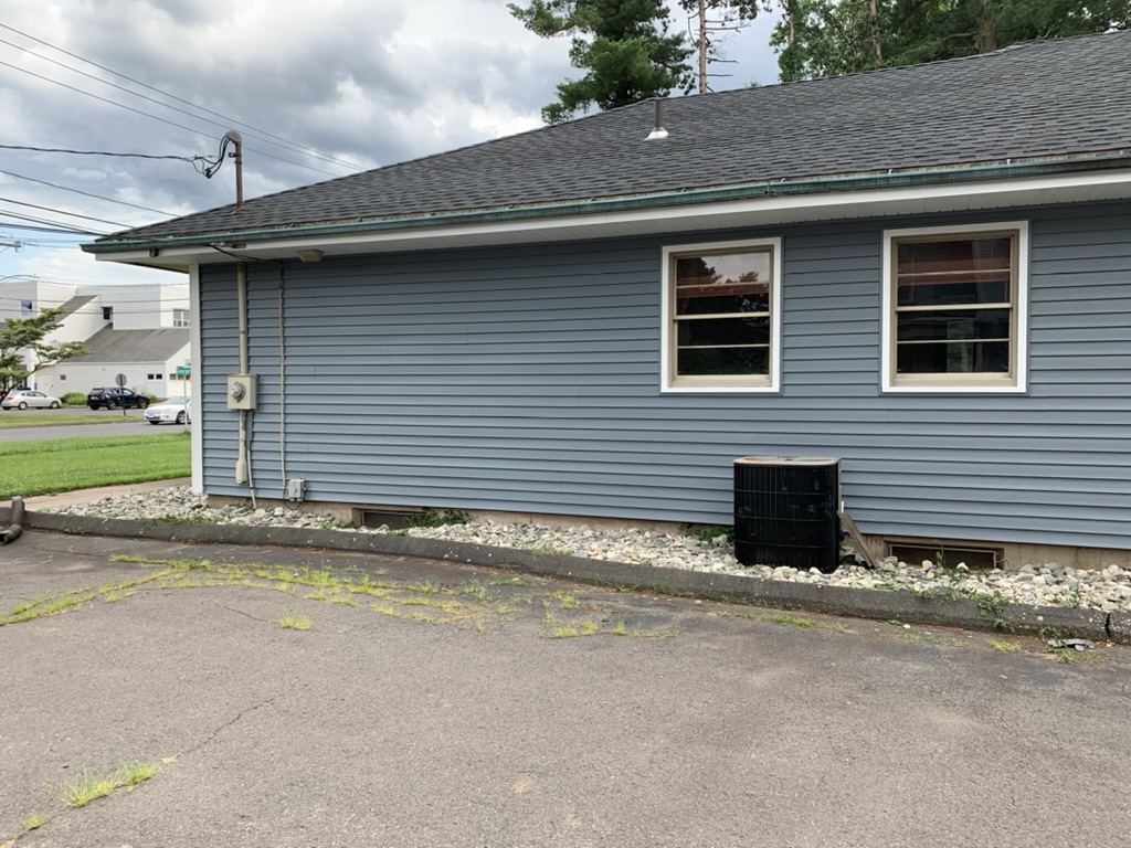 Side of 10 George Avenue after re-siding in blue vinyl with windows and stone border