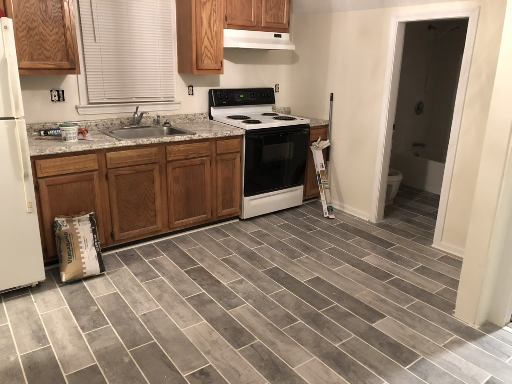 Kitchen mid-renovation with new tile floor laid and oak cabinets installed at 36 Pratt Street