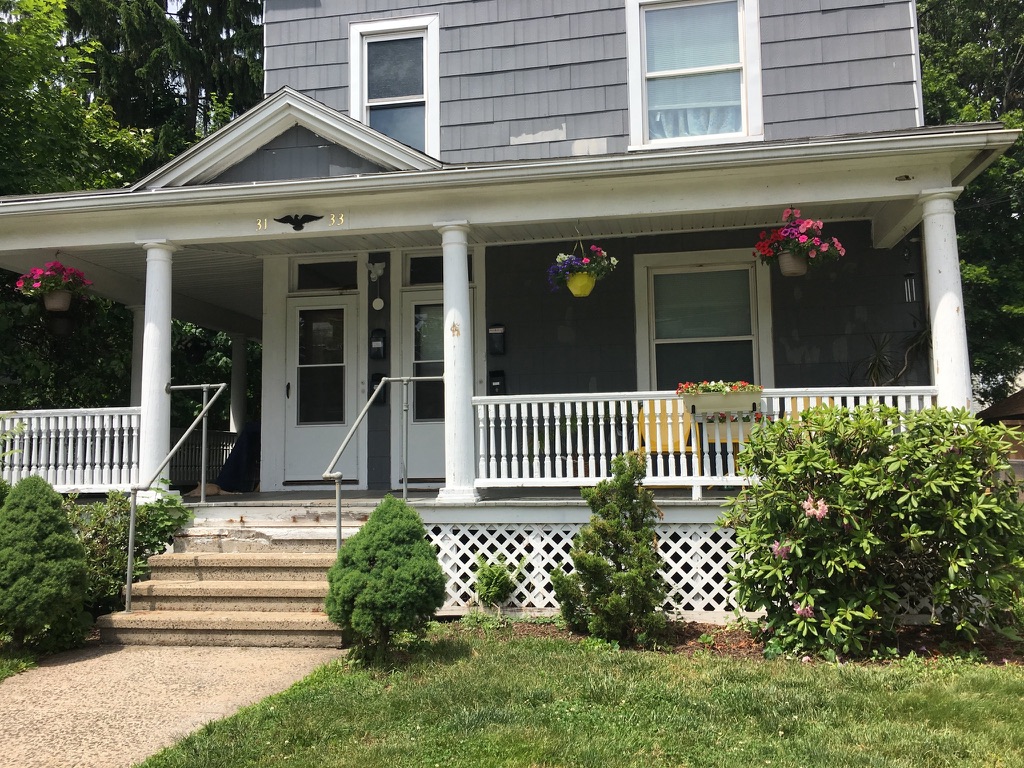 31 Wallace Street exterior after renovation, gray shingle siding with white columned porch