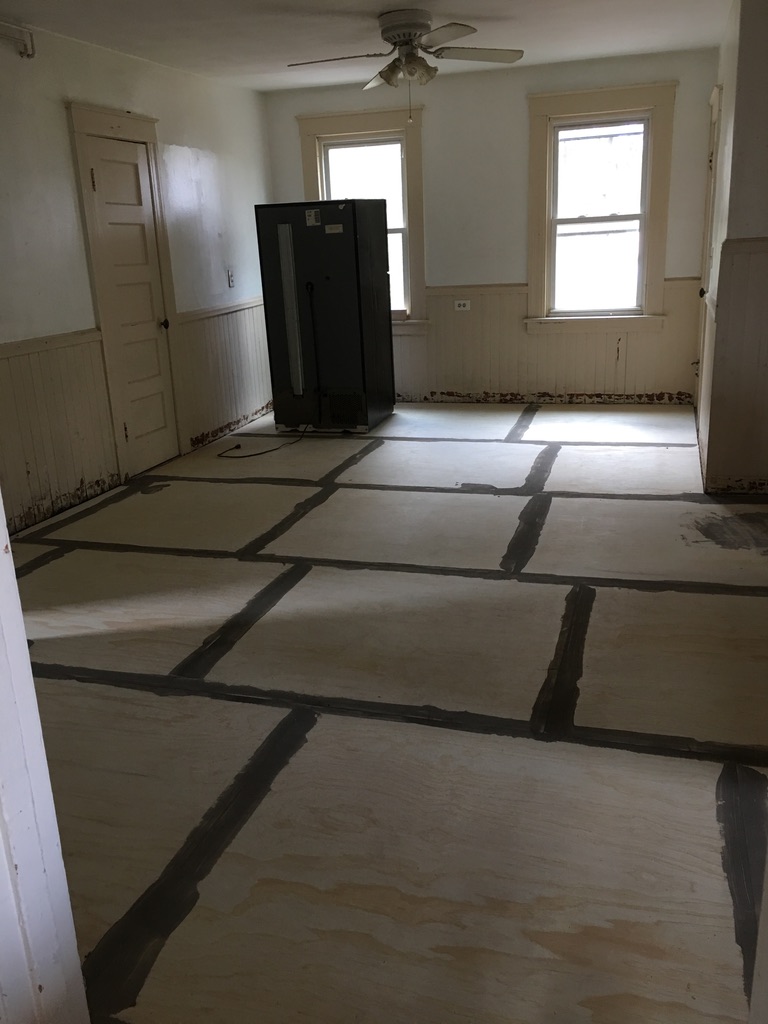 Kitchen mid-renovation with new plywood subfloor and beadboard wainscoting at 31 Wallace Street