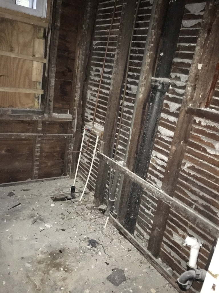Exposed wall framing with new copper and PVC plumbing rough-in at 31 Wallace Street